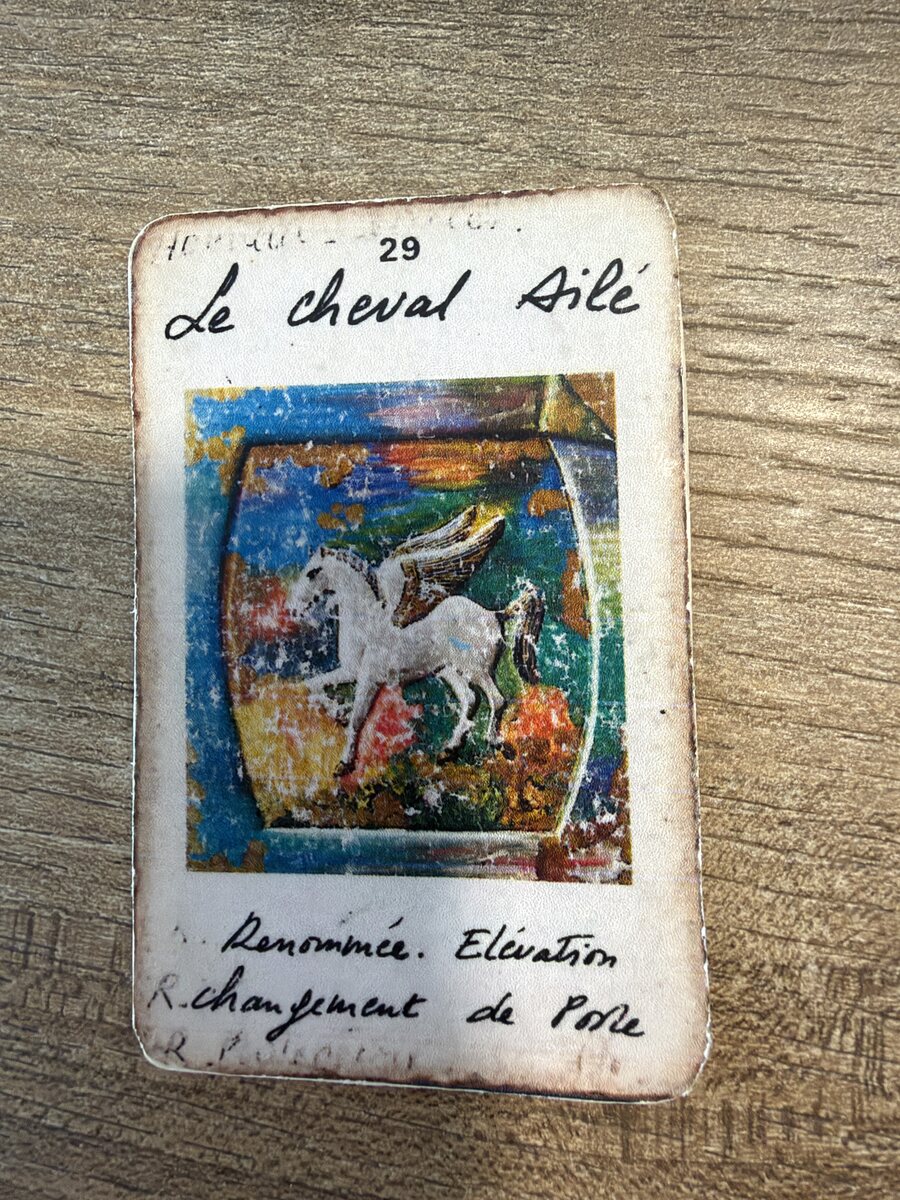 La carte d'origine Le Cheval Ailé, photographiée, usée et annotée à la main.