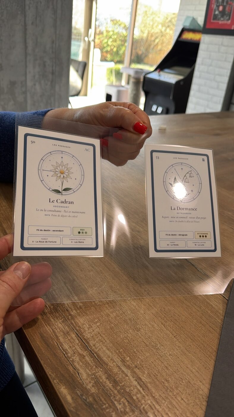Deux cartes du prototype Isayan, Le Cadran et La Dormance, tenues en main.